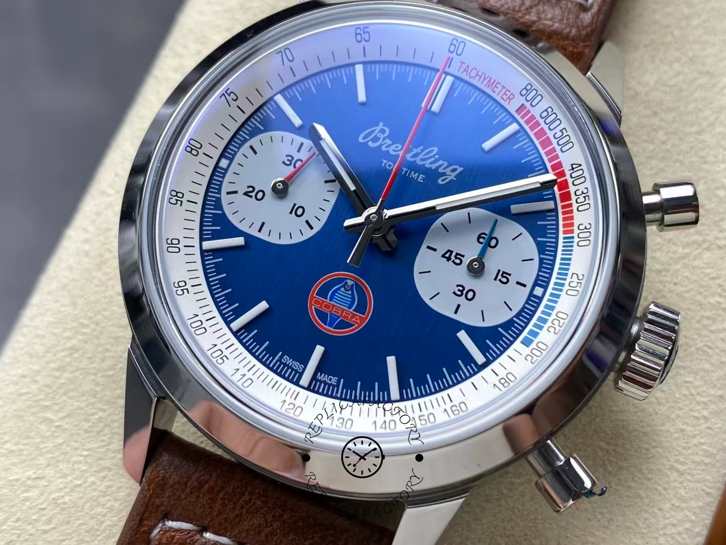 Close-up of blue dial Breitling Top Time B01 Shelby Cobra AB01763A1C1X1 with Cobra logo.