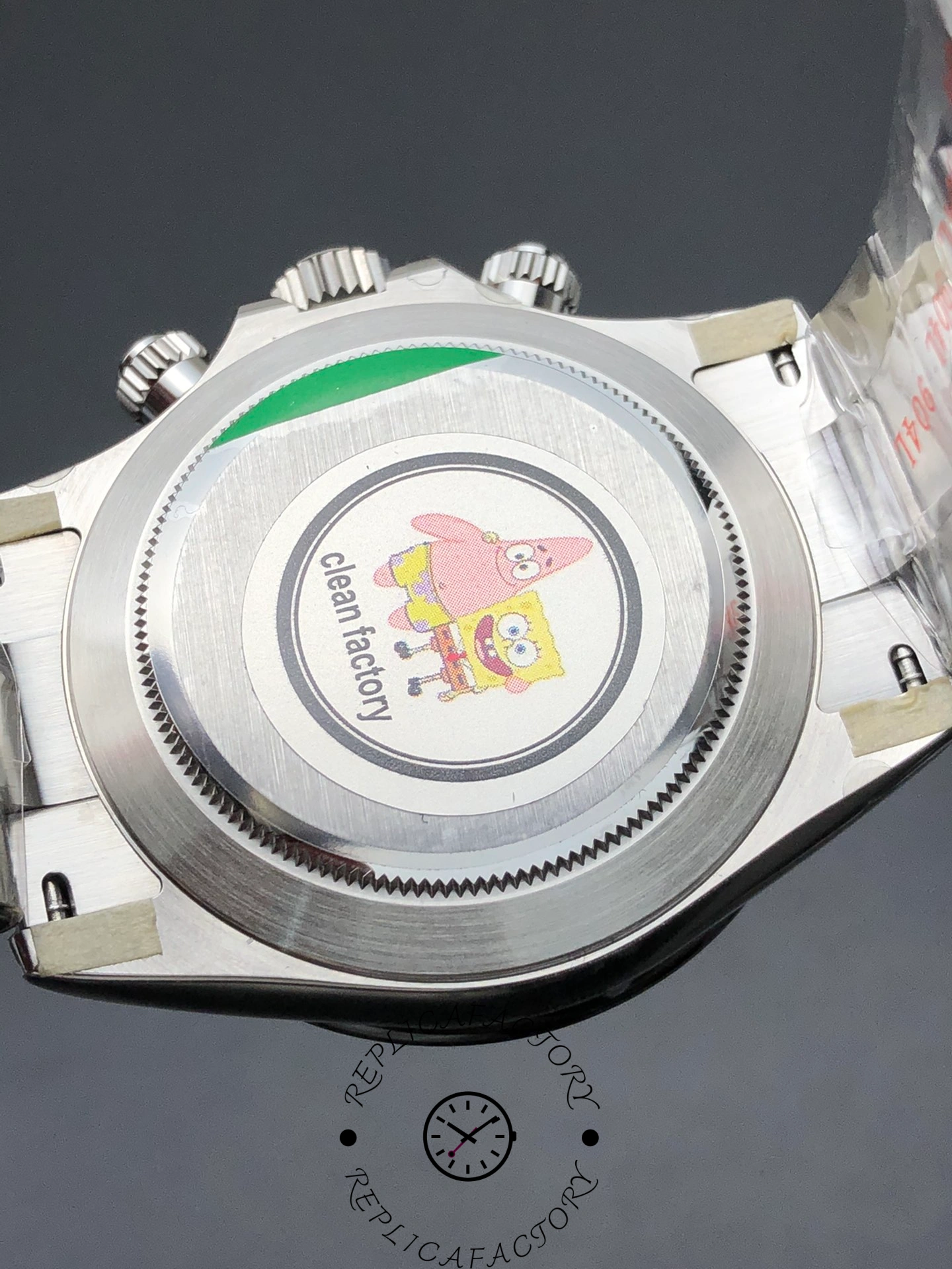 Caseback of Rolex Daytona 116500LN-0001 with “clean factory” sticker featuring cartoon design.