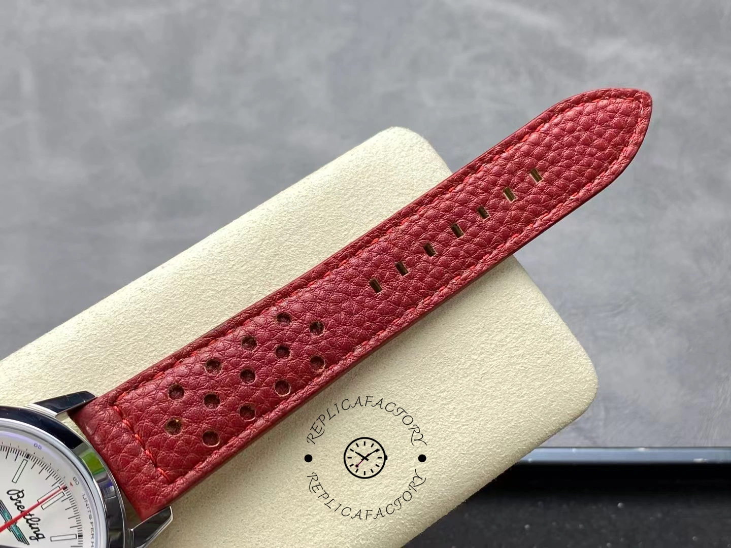 Red perforated leather strap of Breitling Premier B01 AB0176A71A1X1 close-up view.