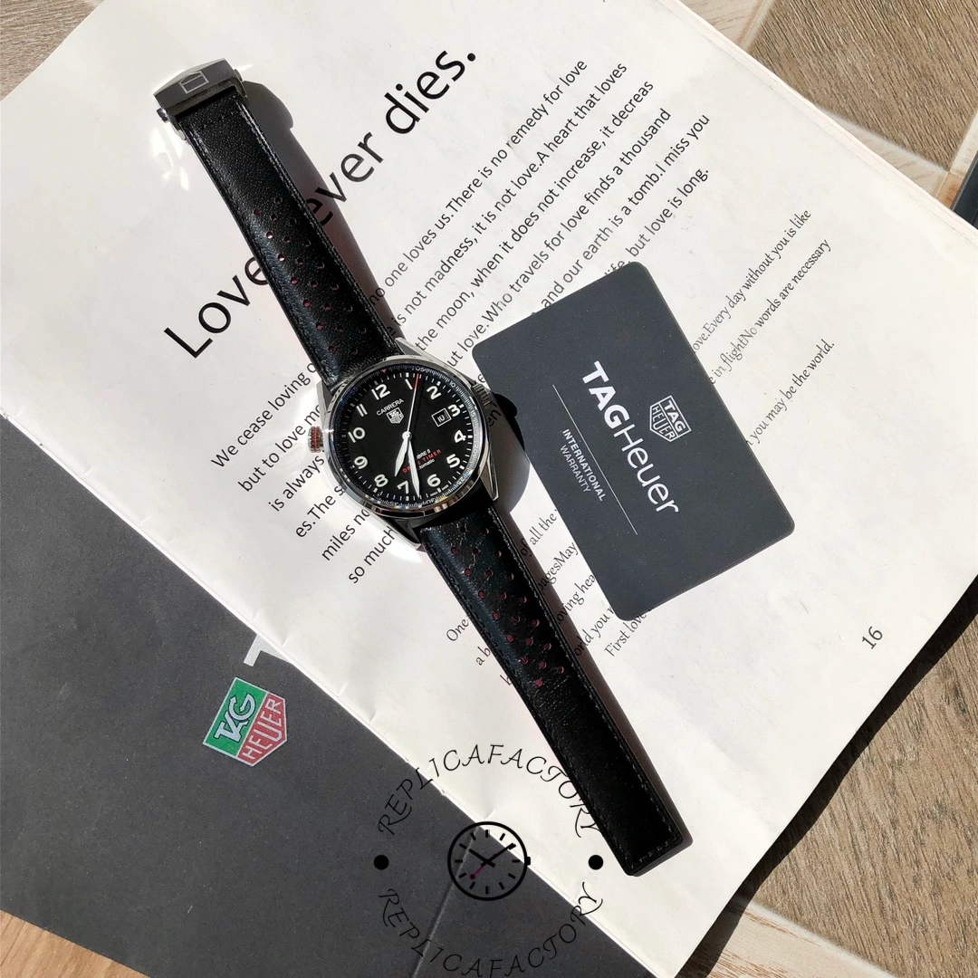 Flat lay of TAG Heuer Carrera Calibre 5 WAR2A10.FC6337 with strap and warranty card.