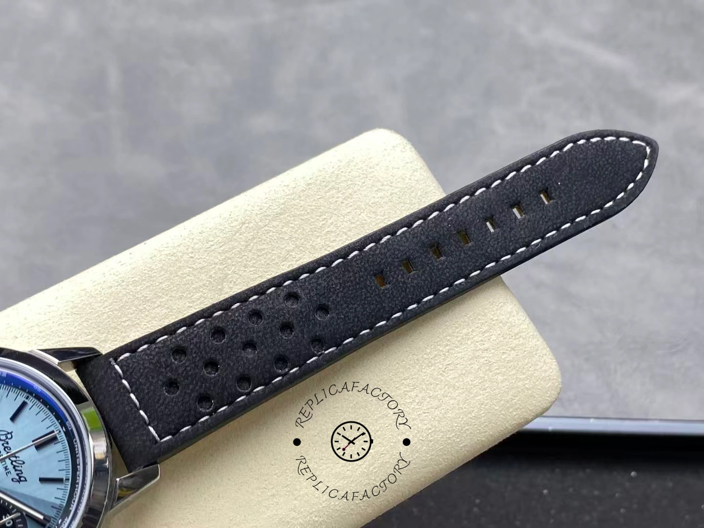 Perforated black leather strap of Breitling Top Time B01 Triumph AB017641C1X1 close-up.