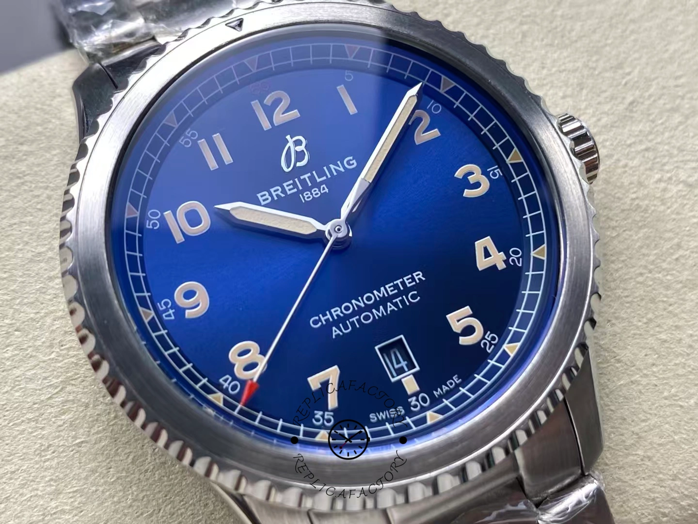 Angled close view of Breitling Aviator 8 A17315101C1A1 highlighting luminous beige hands on blue dial.