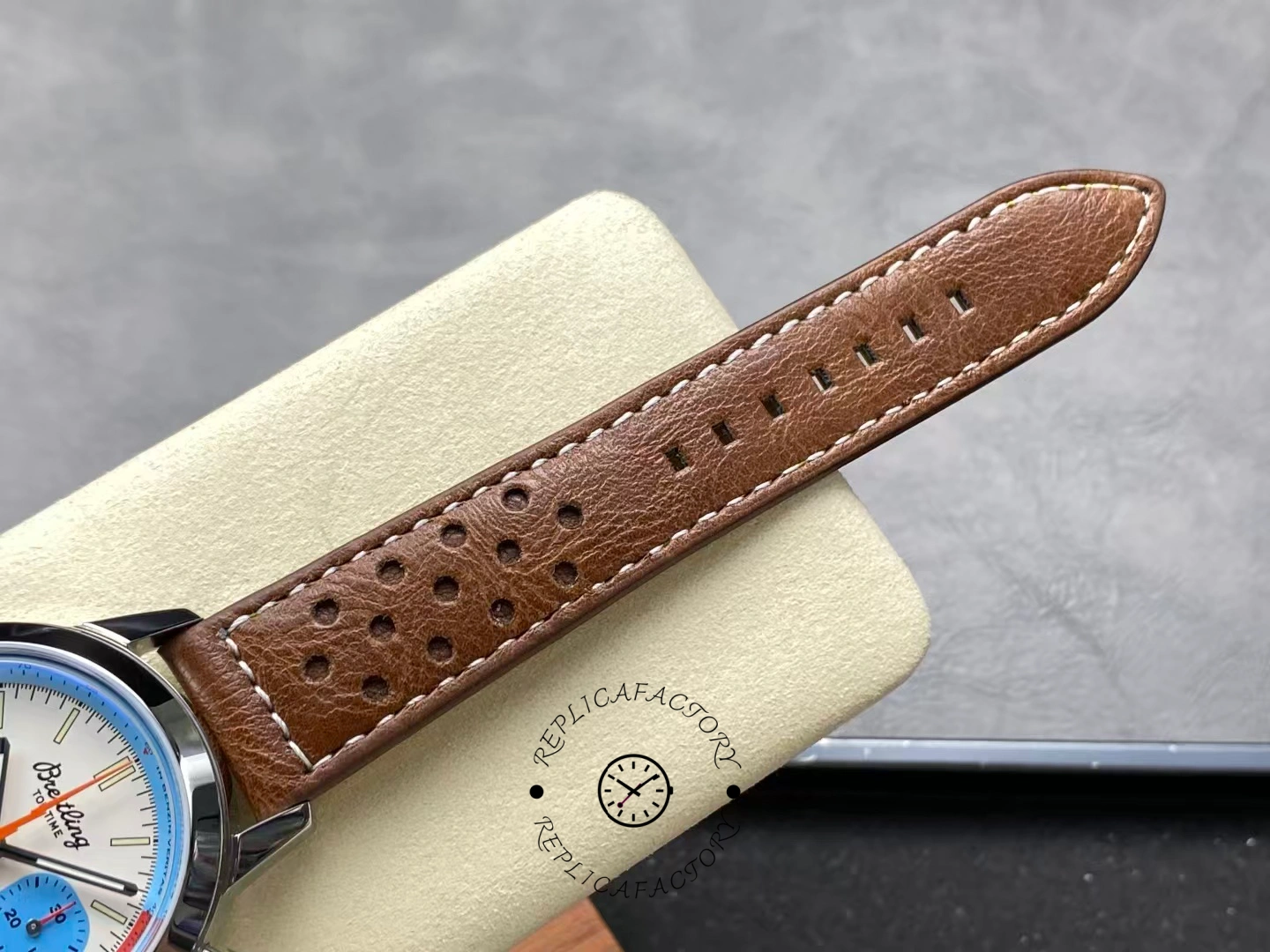 Perforated brown leather strap of Breitling Top Time Deus A233112A1A1X1 close-up.