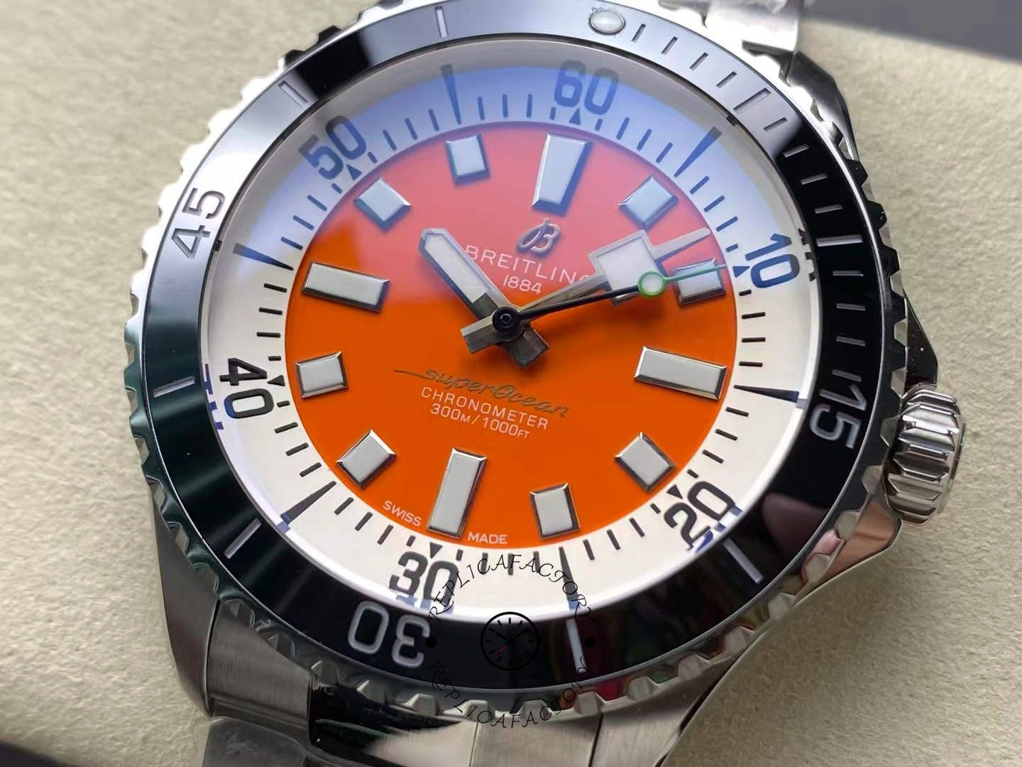 Close-up of Breitling Superocean 42 A173751A1O1S1 orange dial with luminous markers.