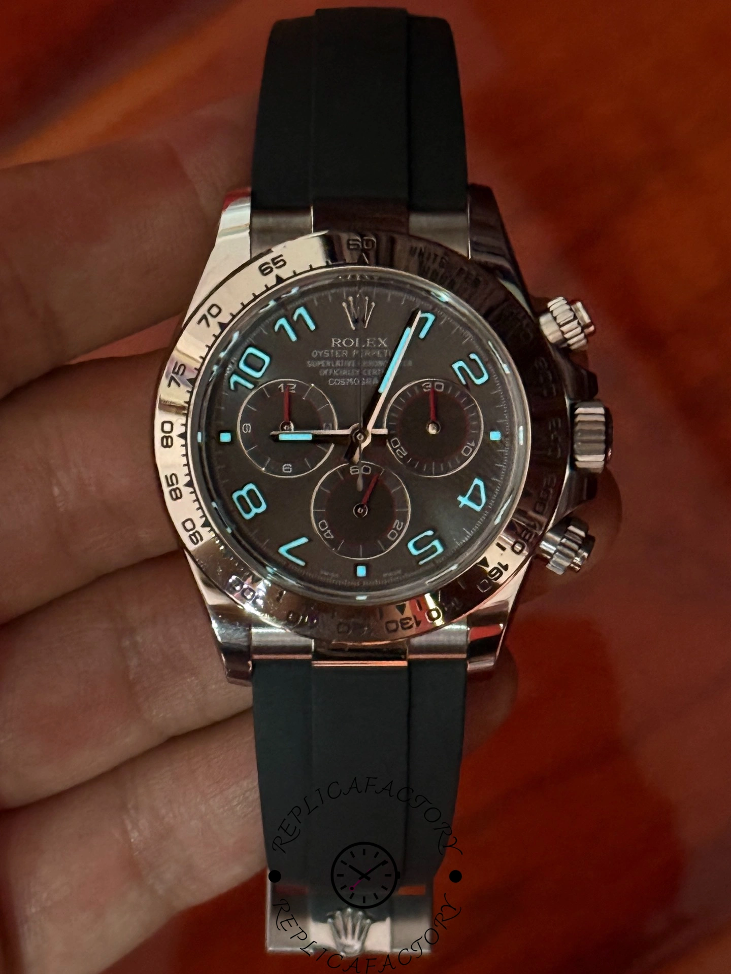 Lume view of the Rolex Daytona 116519 showing glowing Arabic numerals and hands against the dark background.