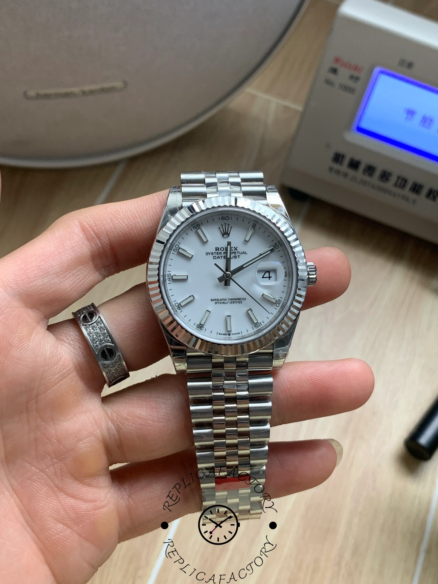 Handheld view of the Rolex Datejust 41 M126334-0010 with white dial and fluted bezel.