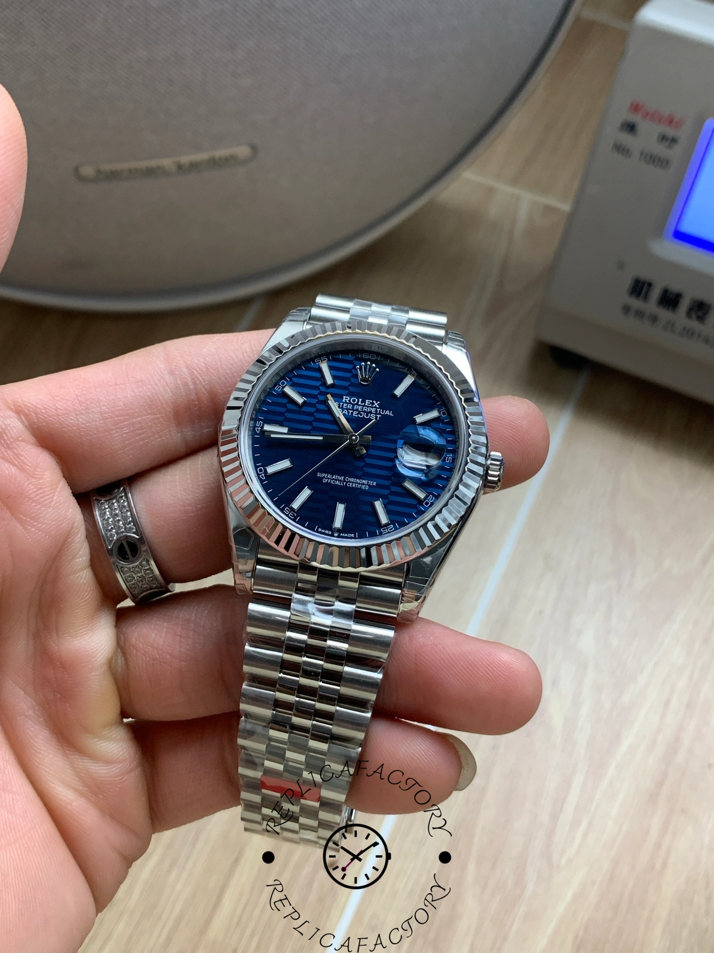 Close-up of Rolex Datejust 126334 blue dial with fluted bezel in hand.