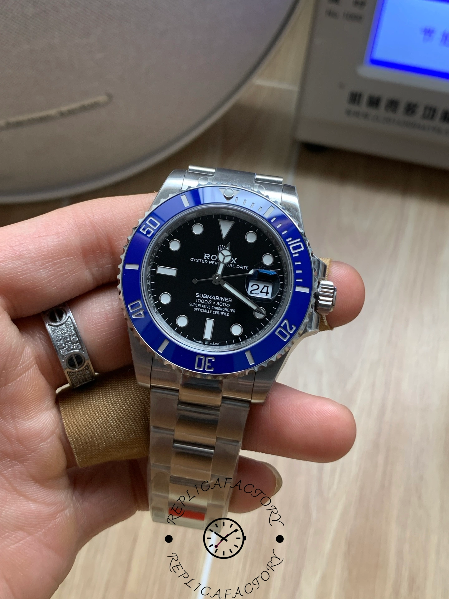 Close hand-held view of Rolex Submariner 126619LB with blue bezel and date window.