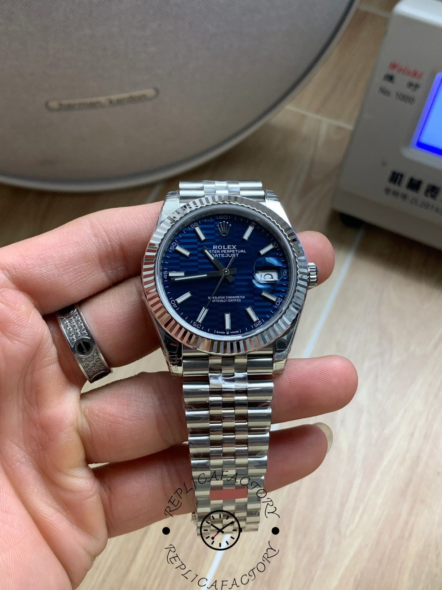 Hand-held Rolex Datejust 126334 showing blue textured dial and fluted bezel.
