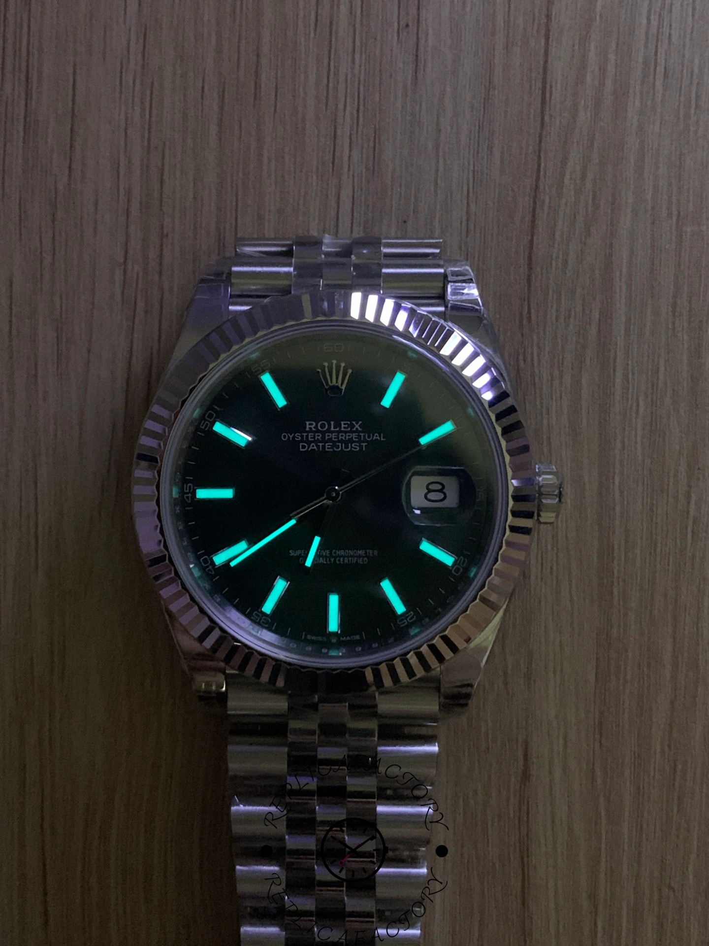 Lume shot of Rolex Datejust 126334 VS showing glowing markers on green dial.