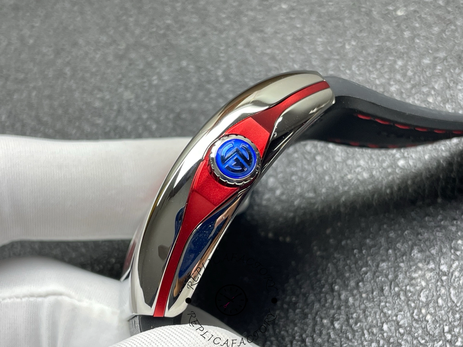 Crown side view of the Franck Muller V 45 SC DT RCG showing the blue FM crown and red accents.