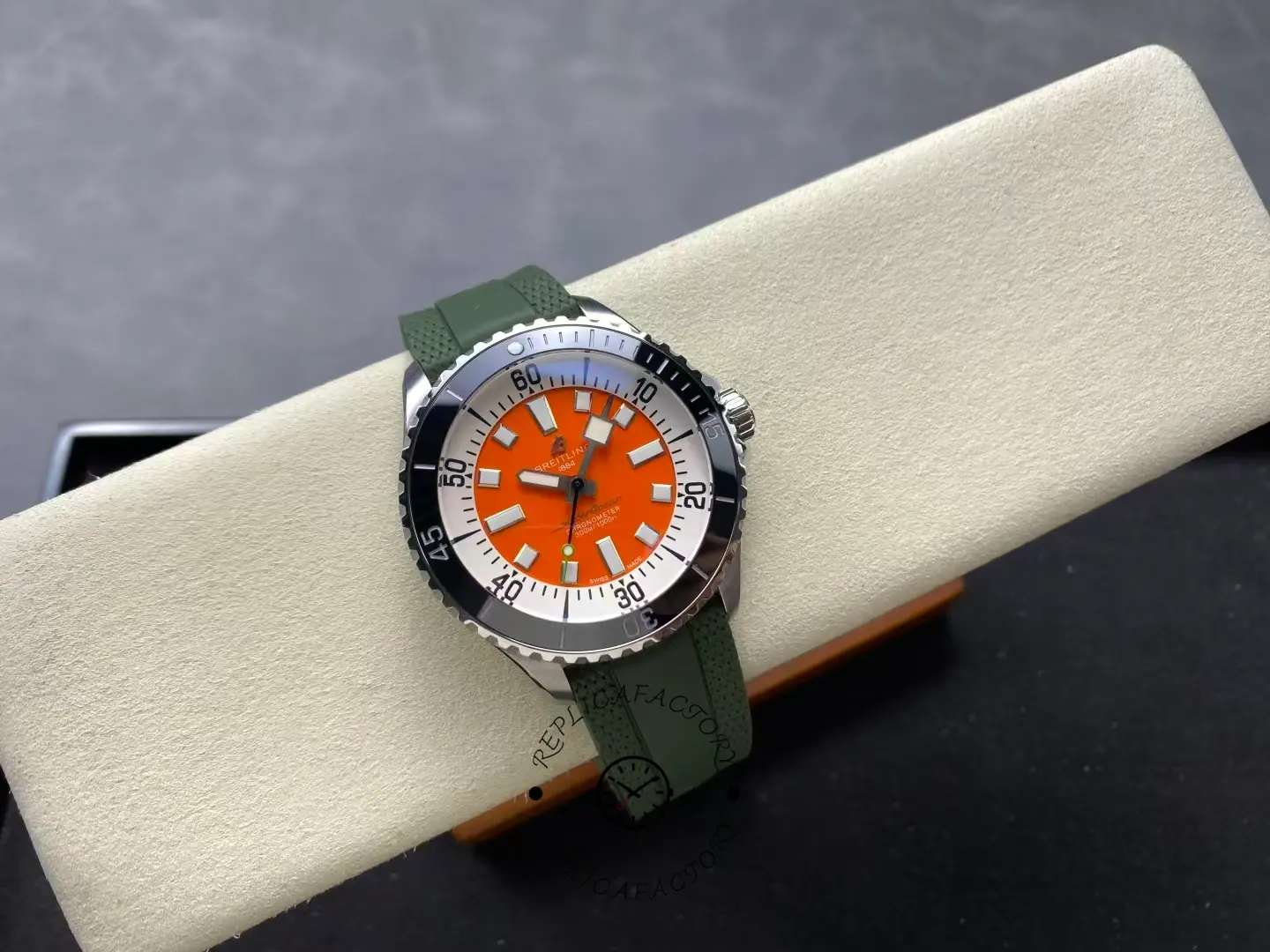 Straight-on shot of Breitling Superocean A173751A1O1S1 orange dial and green strap.