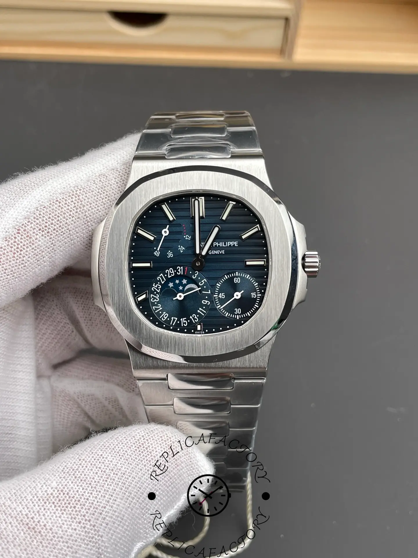 Hand-held view of the Patek Philippe Nautilus 5712/1A-001 showing textured blue dial and subdials.
