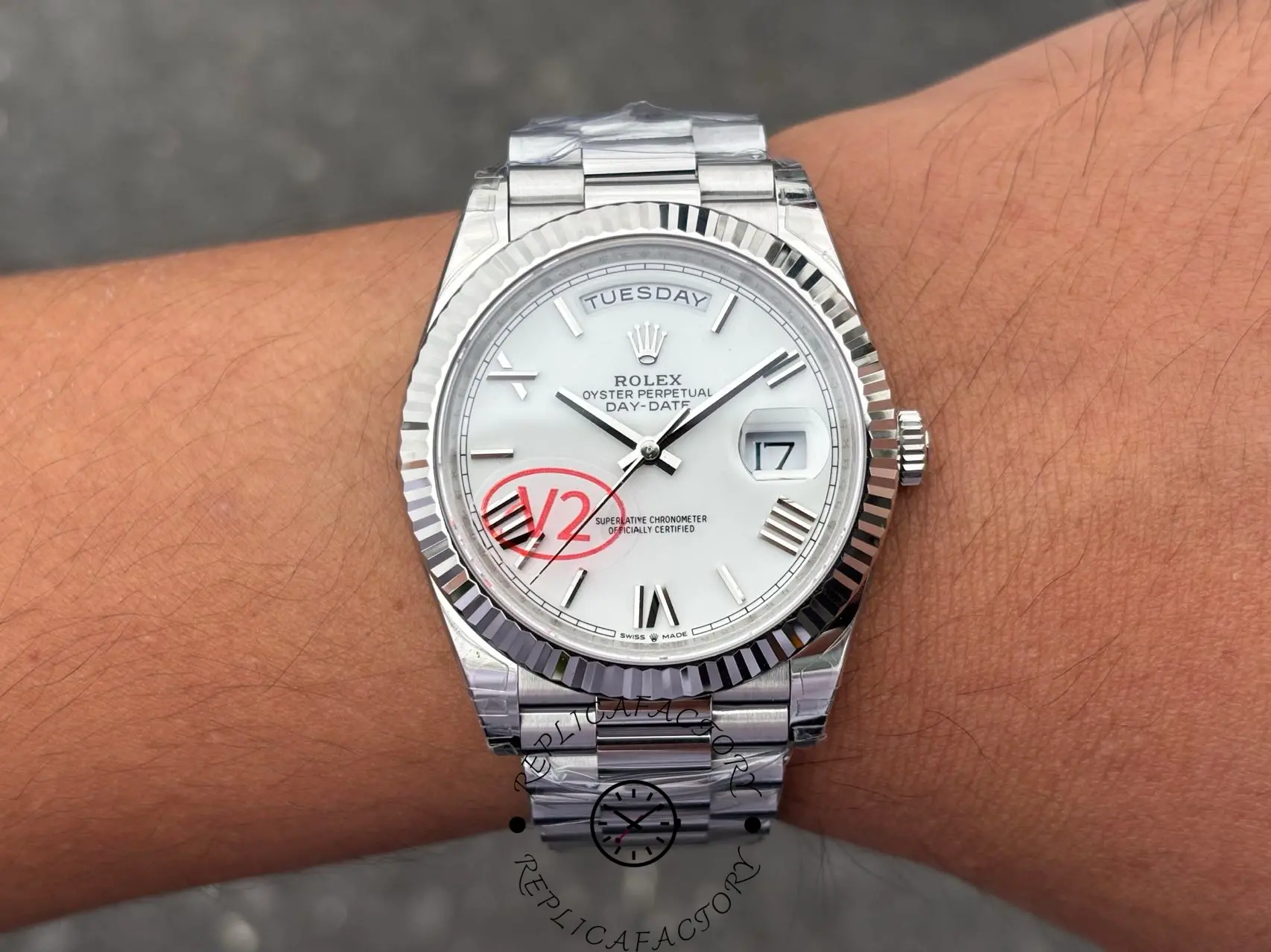 Wrist shot of Rolex Day-Date 228239 with white Roman dial and fluted bezel on President bracelet.