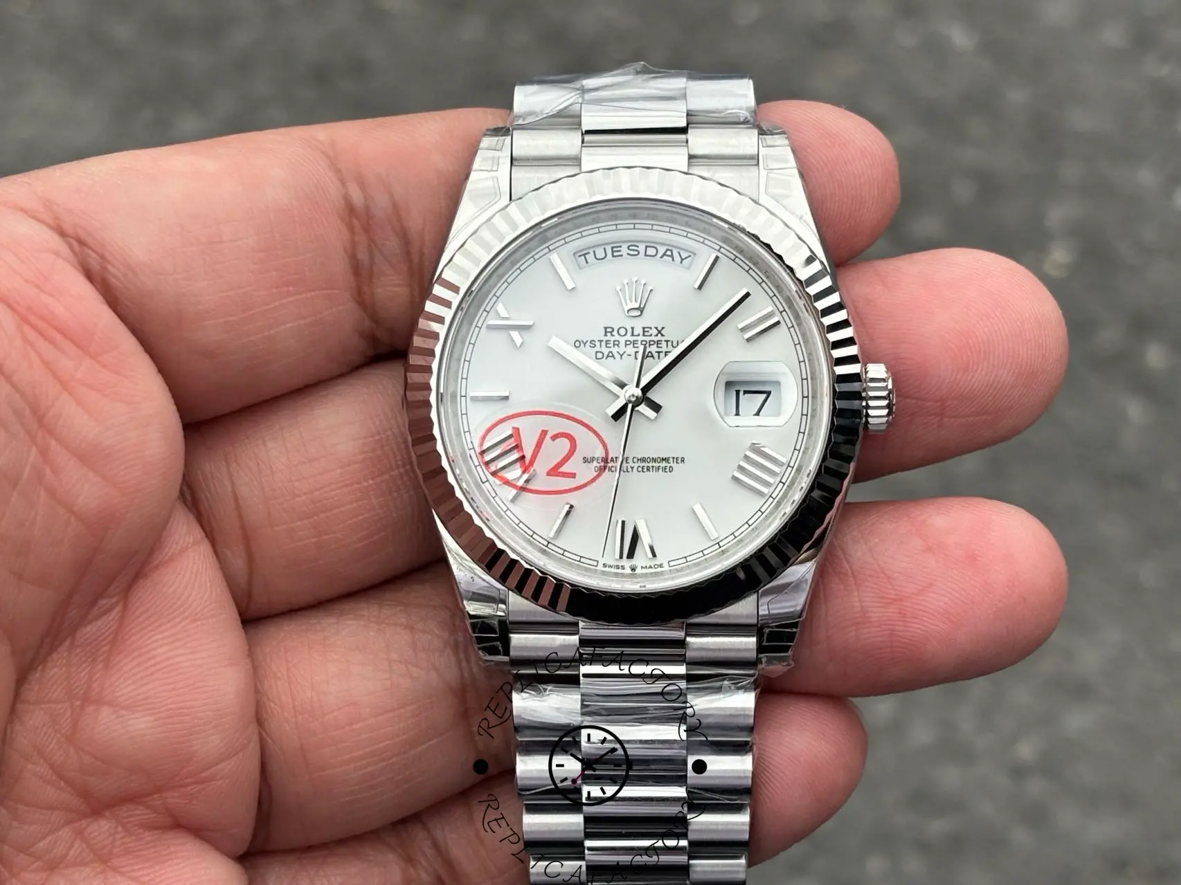 Hand-held shot of Rolex Day-Date 228239 showing white Roman dial and polished white-gold case.