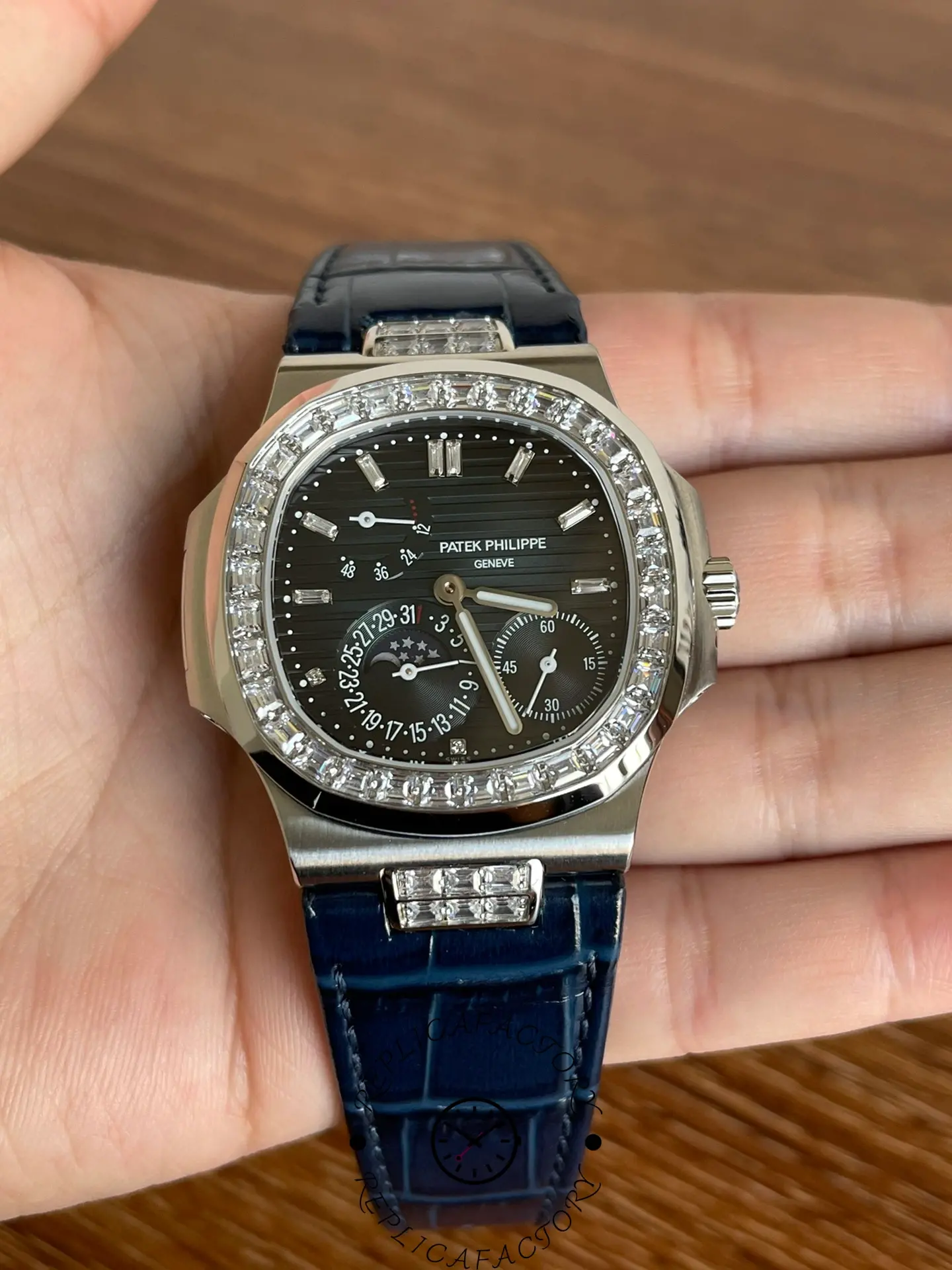 Full front view of Patek Philippe 5724G-001 showing baguette diamond bezel and blue leather strap.