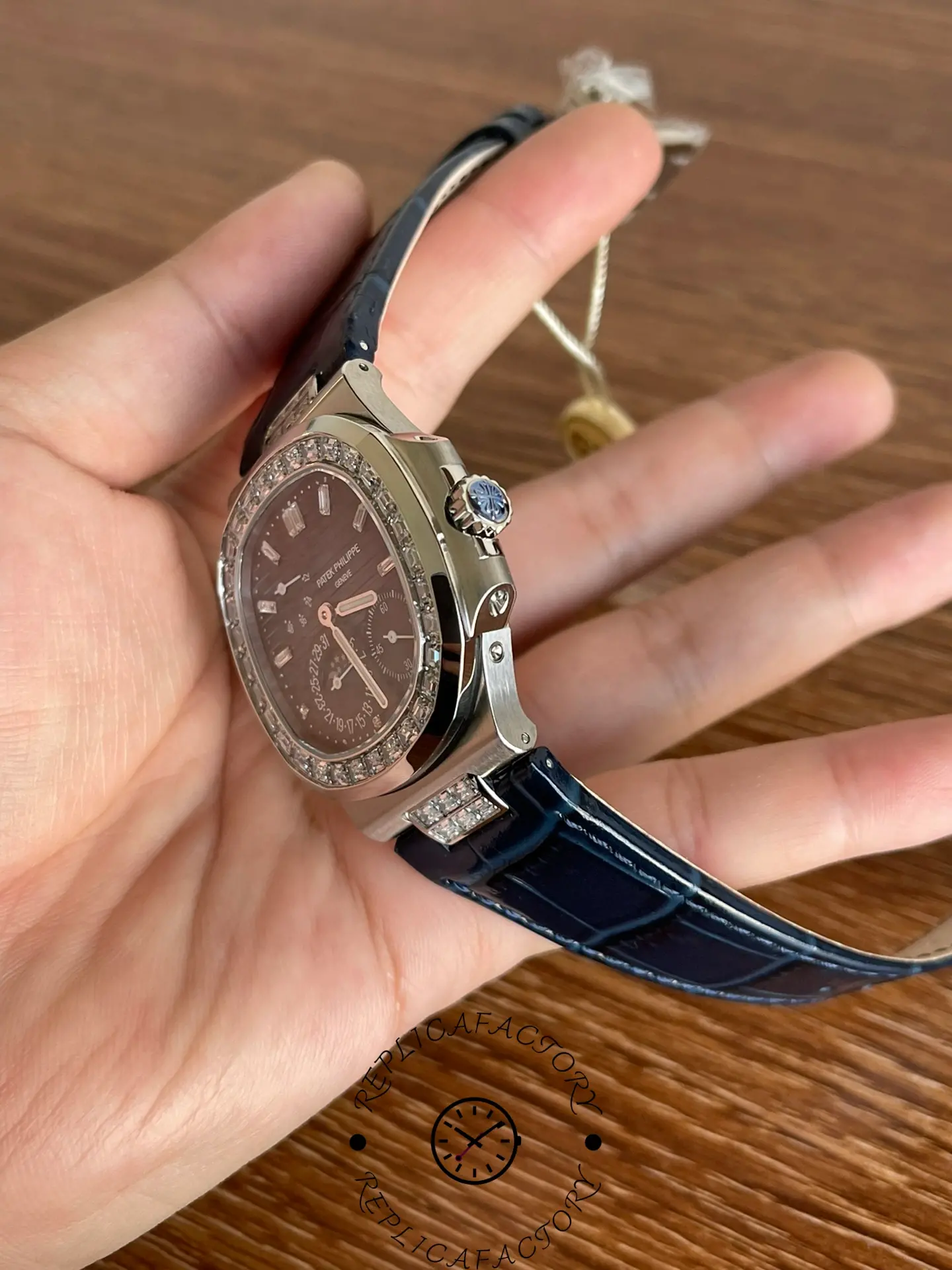 Right-side view of Patek Philippe 5724G-001 featuring crown with blue cabochon and case profile.