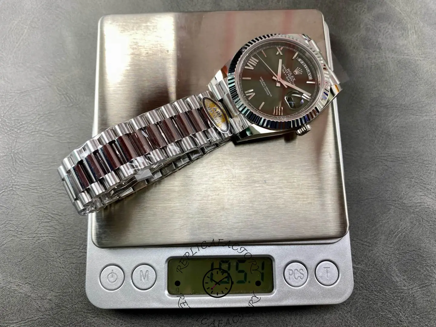 Rolex Day-Date 228239 placed on a scale showing total watch weight.