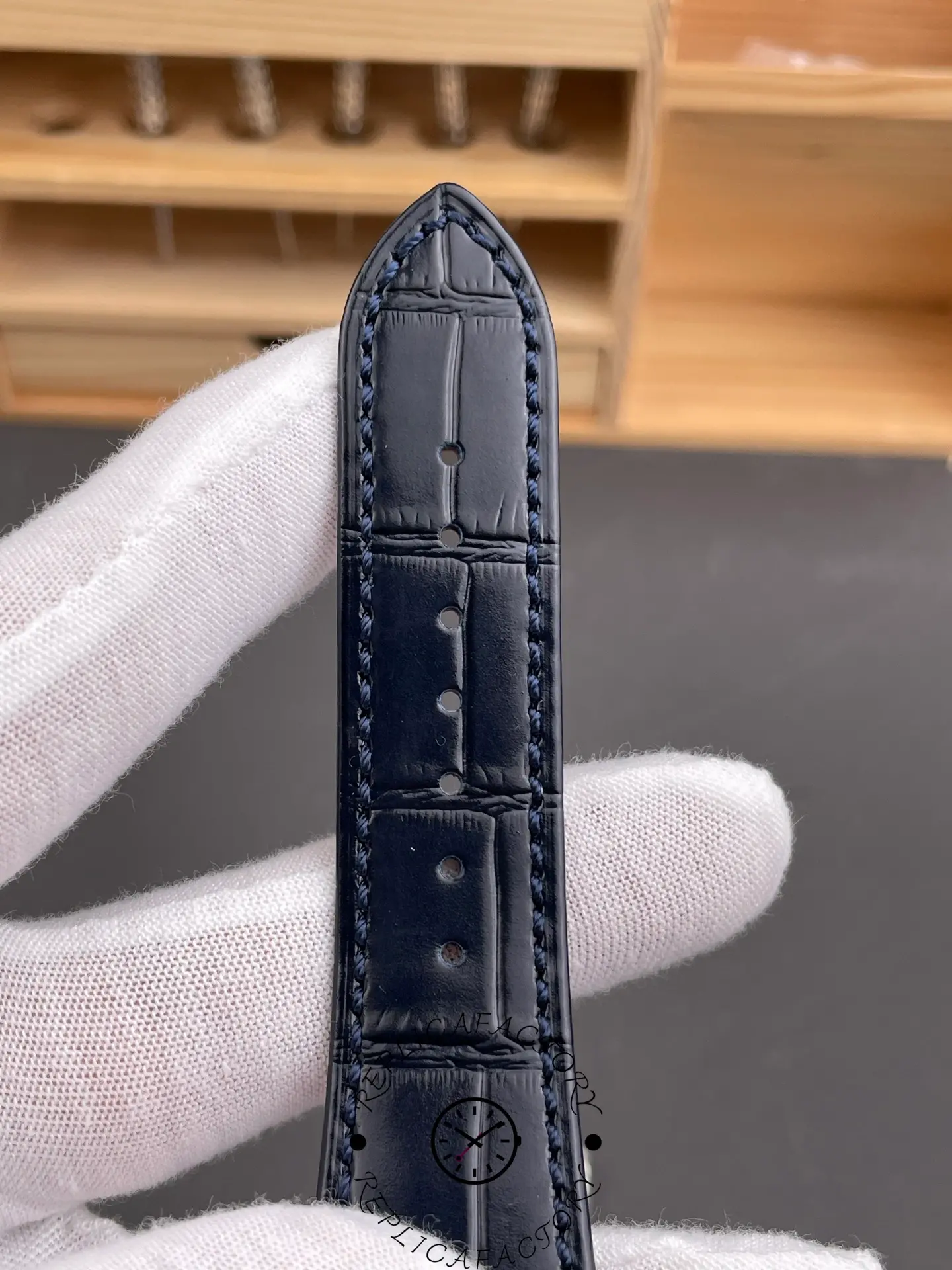 Close-up of blue leather strap of Patek Philippe 5724G-001 showing stitching and texture.