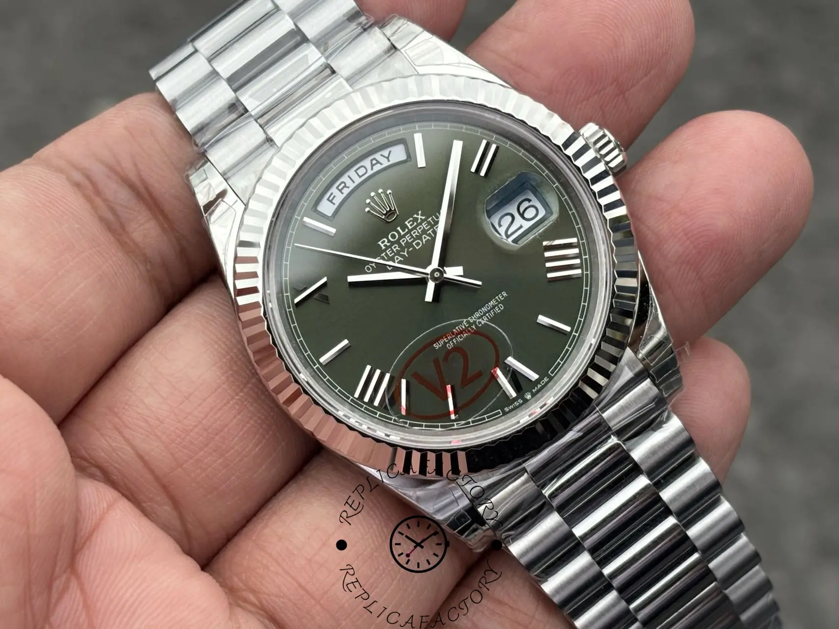 Angled wrist view of Rolex Day-Date 228239 showing green dial, fluted bezel, and President bracelet.