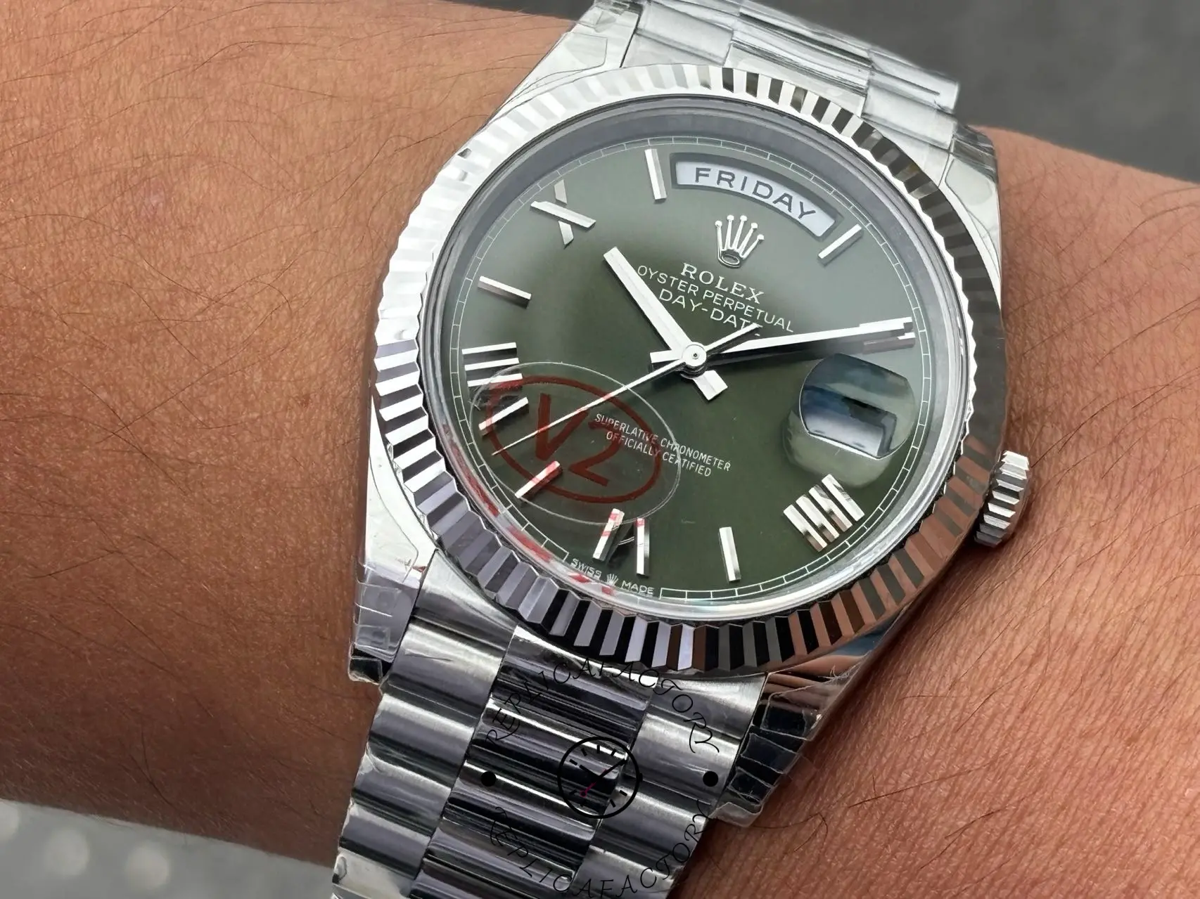 Close-up hand-held shot of Rolex Day-Date 228239 displaying green Roman dial and date magnifier.