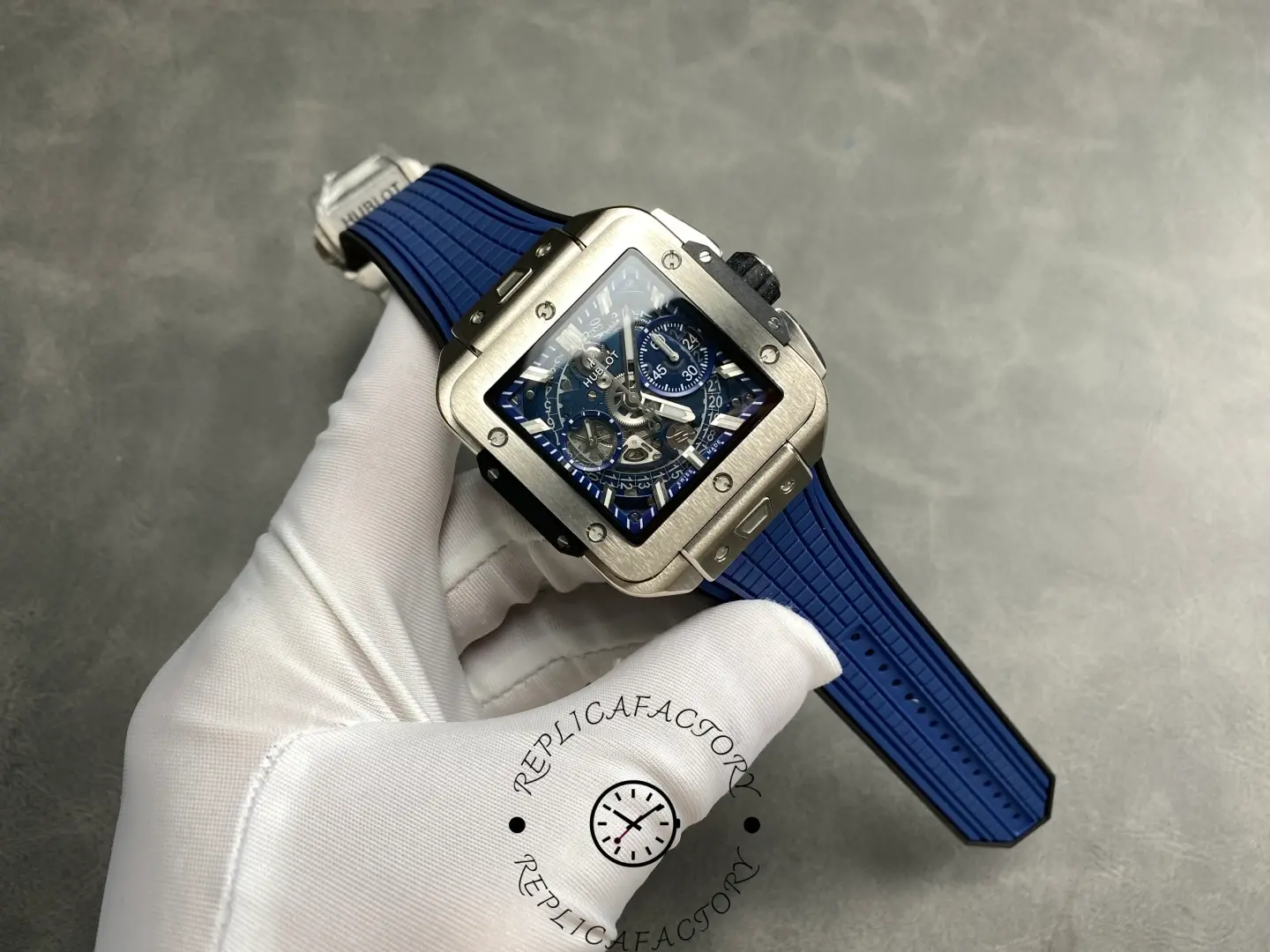 Wrist-level view of Hublot Square Bang Unico 821.NX.5170.RX with blue rubber strap.