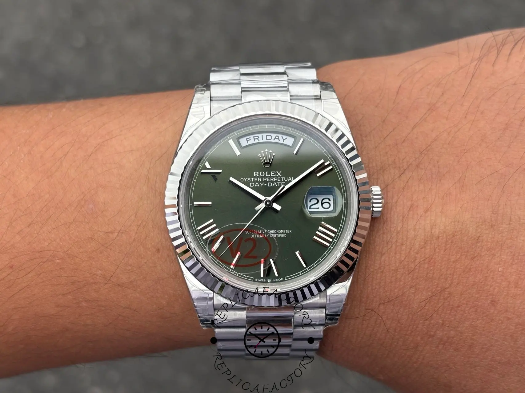Wrist shot of Rolex Day-Date 228239 with green Roman dial and fluted bezel in 40mm white gold case.