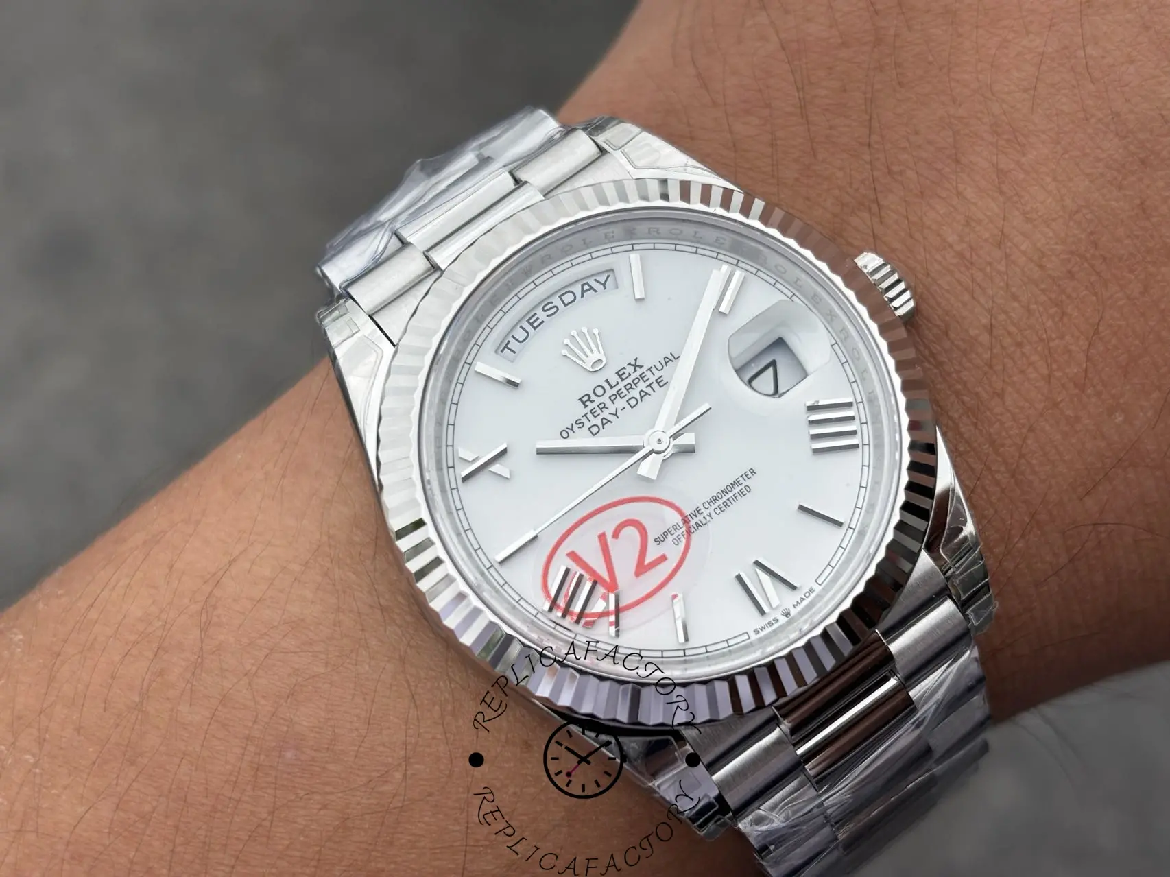 Angled wrist view of Rolex Day-Date 228239 showing fluted bezel and white Roman dial.