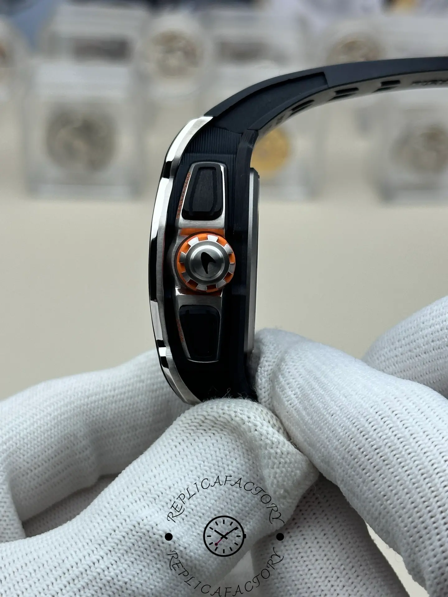 Side close-up of RM 65-01 replica crown with orange rubber grip.