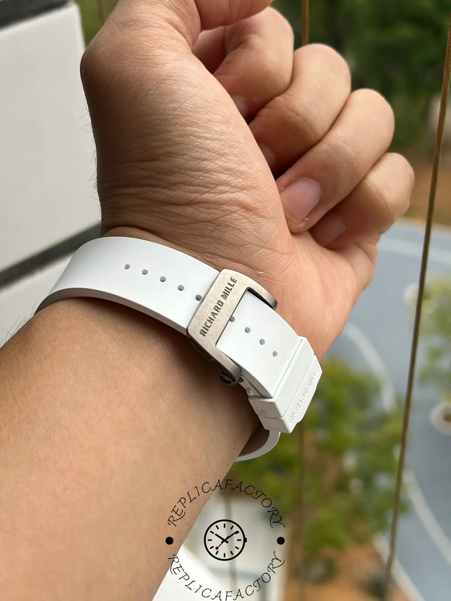 Back clasp shot of RM61-01 replica showing engraved titanium buckle and white strap.