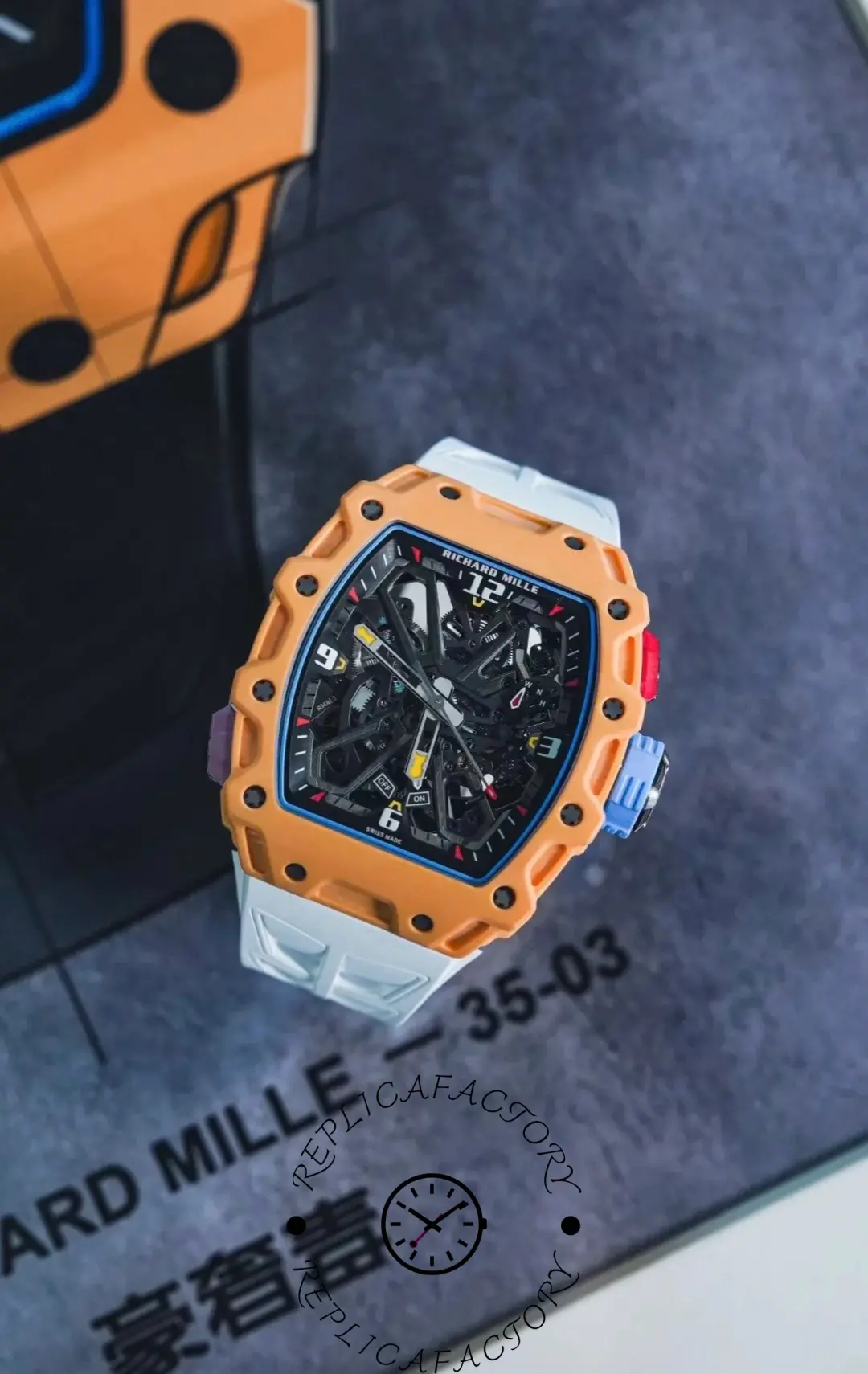 Richard Mille RM35-03 orange bezel watch with skeleton dial and white strap in display case.
