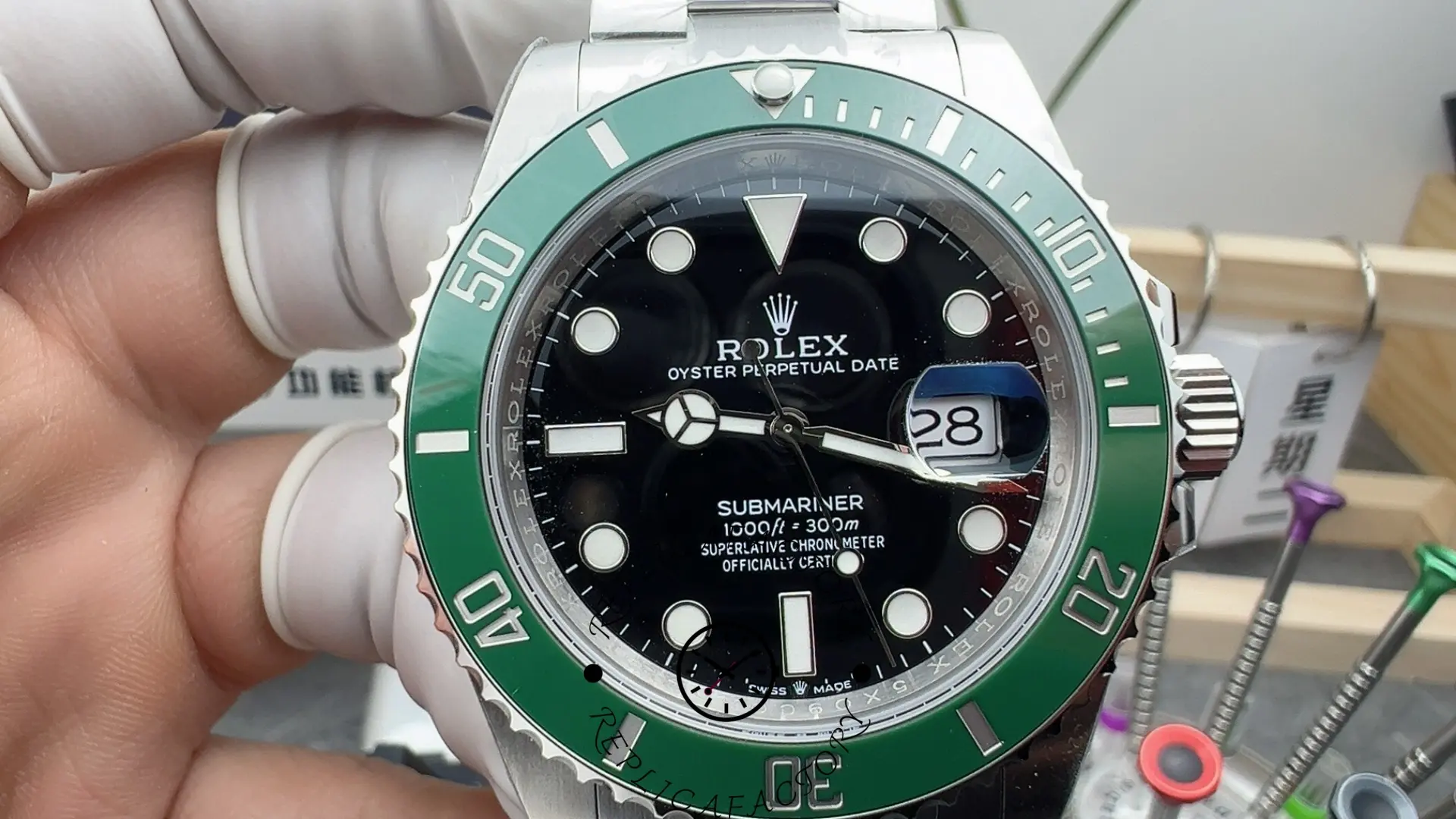 Close-up of the Rolex Submariner 126610LV dial and green bezel held by gloved hand.