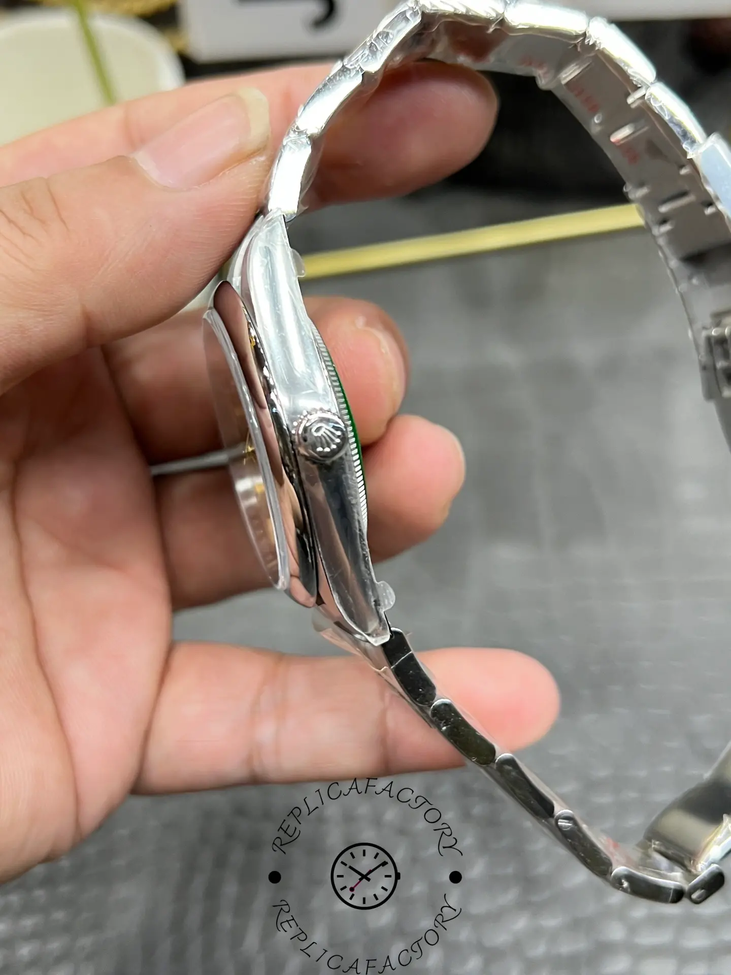 Side profile of Rolex M124300-0001 replica showing steel case and screw-down crown.