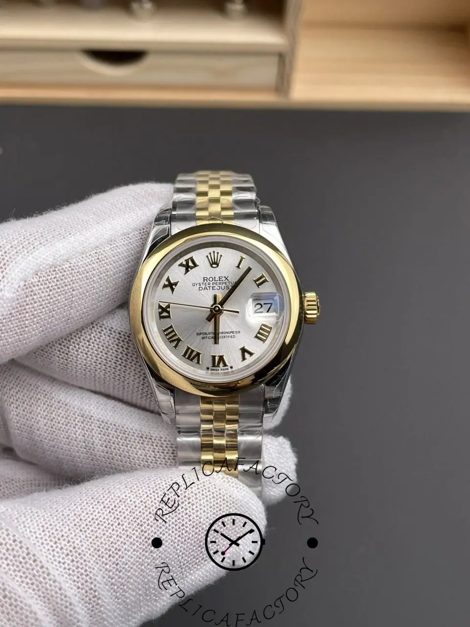 Hand-held close-up of Rolex 279163-0005 replica with polished bezel and silver dial details.