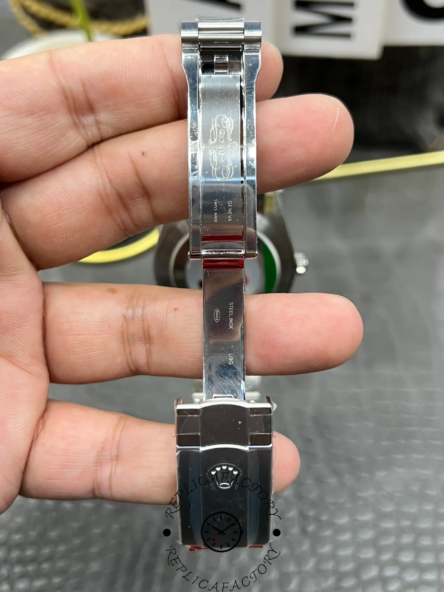 Clasp view of Rolex replica M124300-0001 showing engraved Rolex logo and inner markings.
