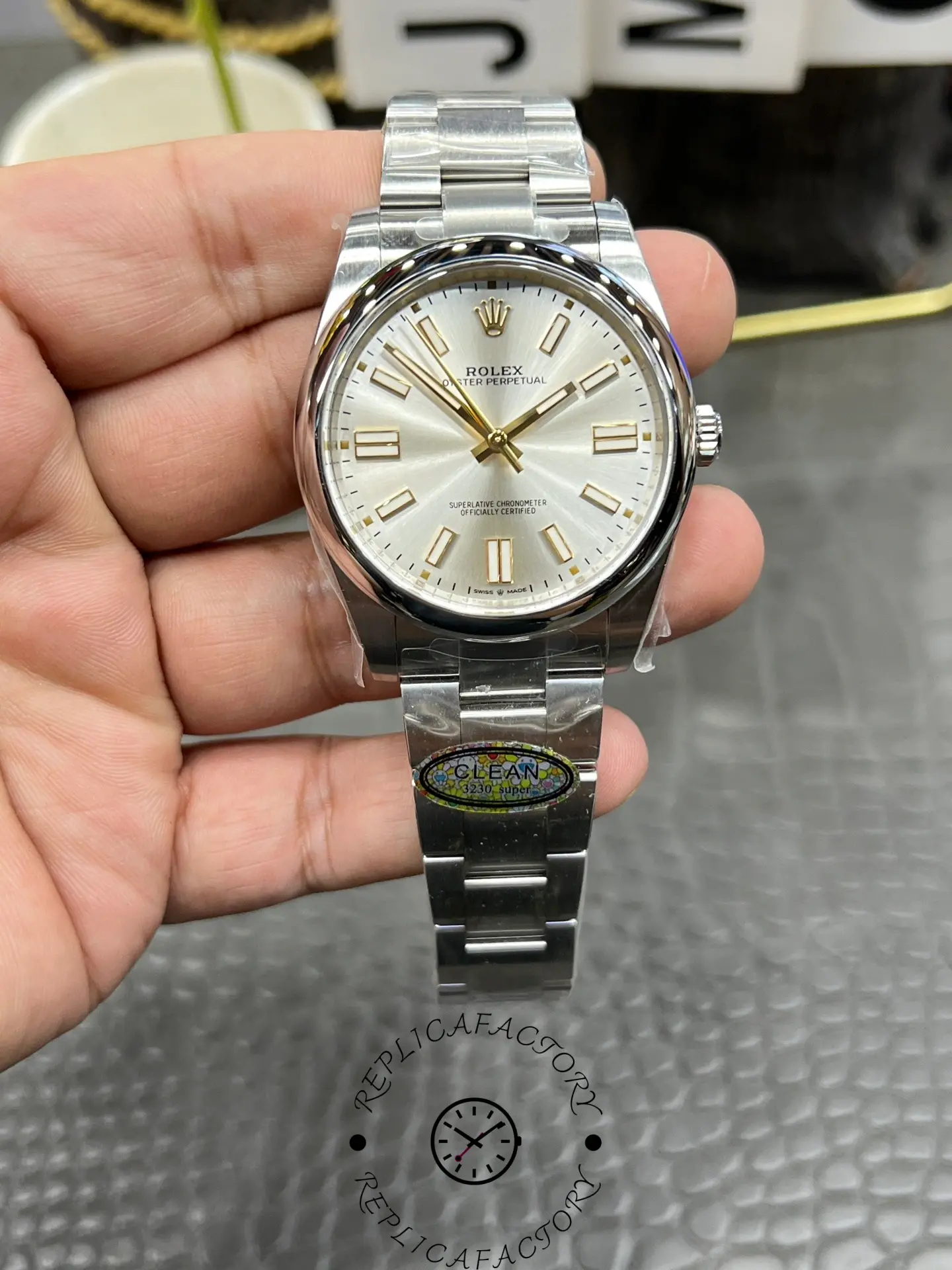Hand-held display of the Rolex M124300-0001 replica showing dial details and markers.