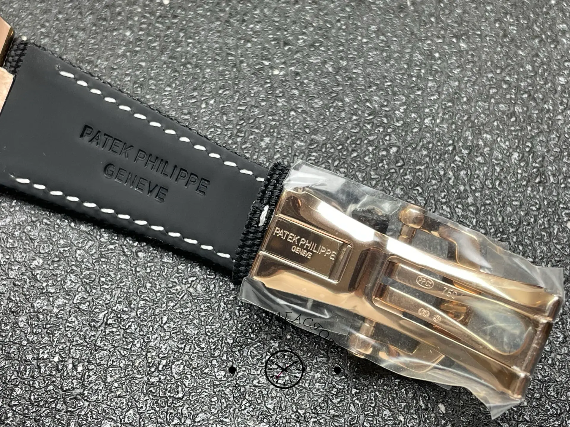 Close-up of Patek Philippe 5822R replica clasp and strap engraving showing buckle details.