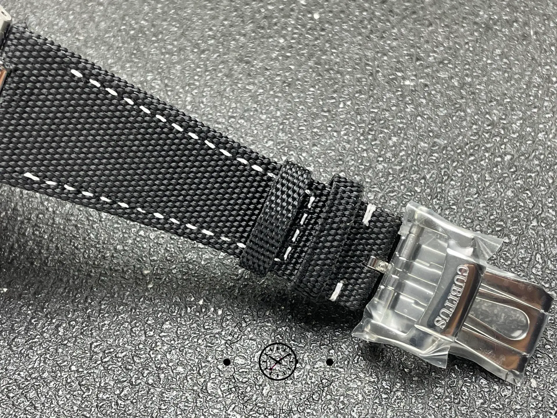 Strap detail of Patek Philippe 5822P showing textile pattern and clasp.
