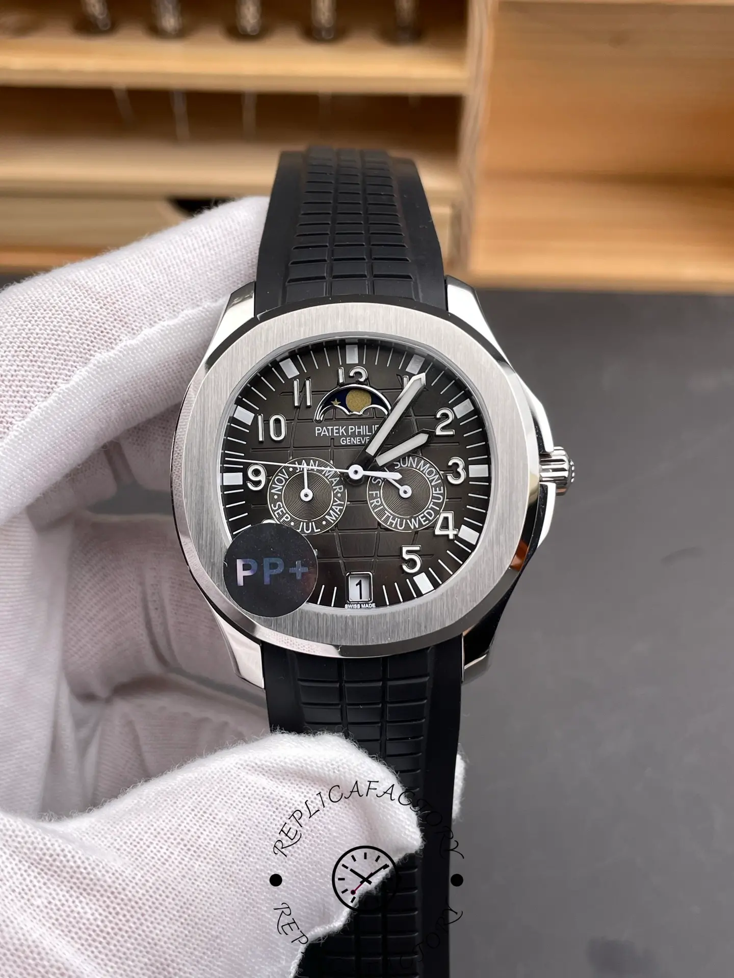 Close-up handheld image of Aquanaut 5261R replica showing calendar subdials and numerals.