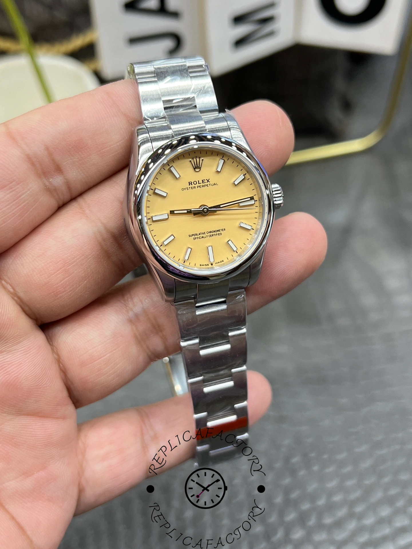 Slightly angled front view of the Rolex Oyster Perpetual 31 277200 replica showing yellow dial and stainless steel bracelet.