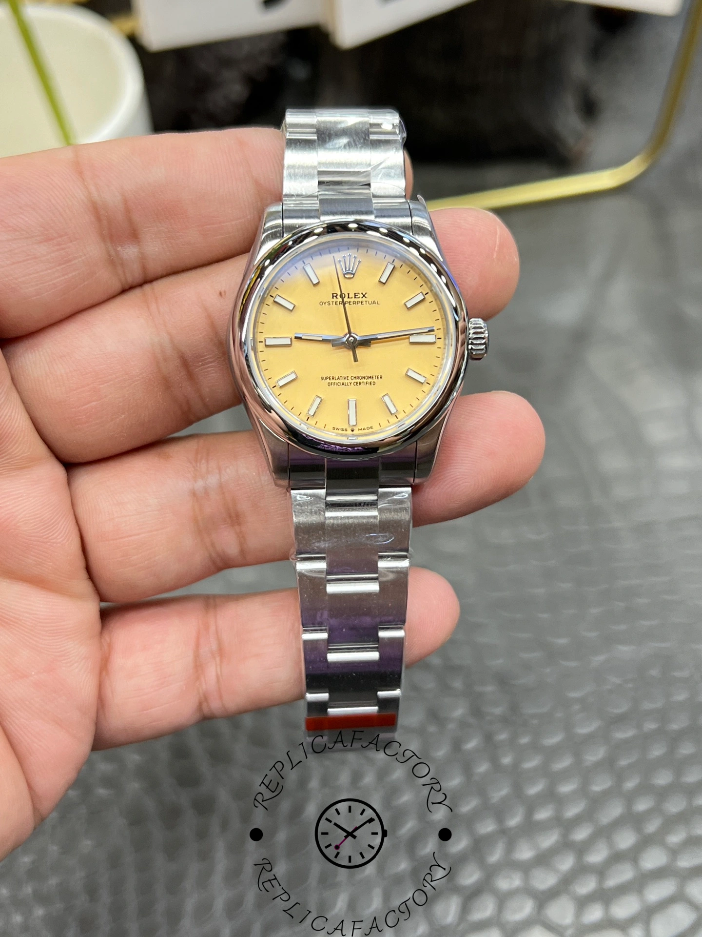 Front view of the Rolex Oyster Perpetual 31 277200 replica showing yellow dial, baton indexes, and stainless steel Oyster bracelet.