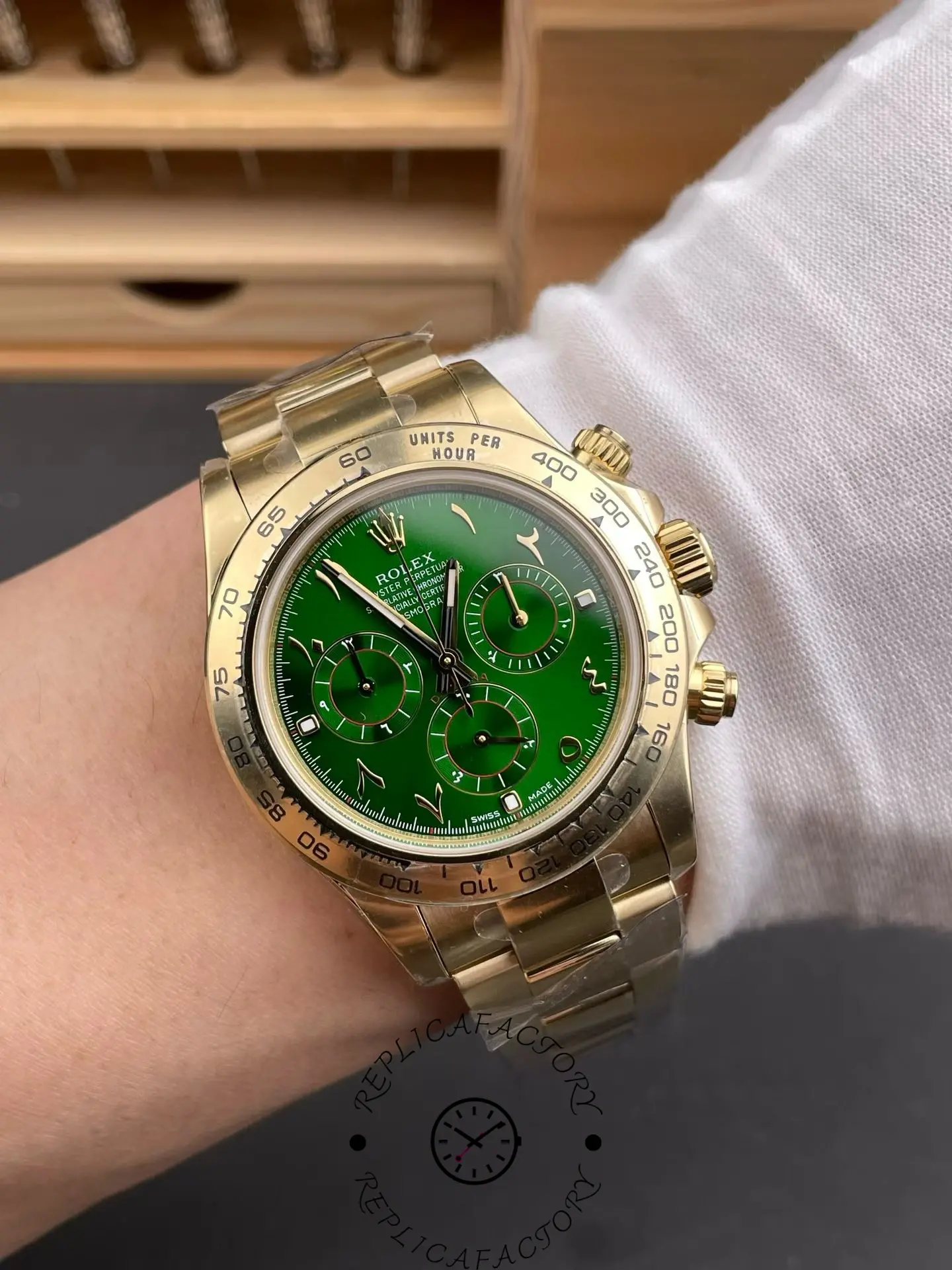 Wrist shot of Rolex Daytona 116508 with green Arabic dial, yellow gold case and tachymeter bezel.