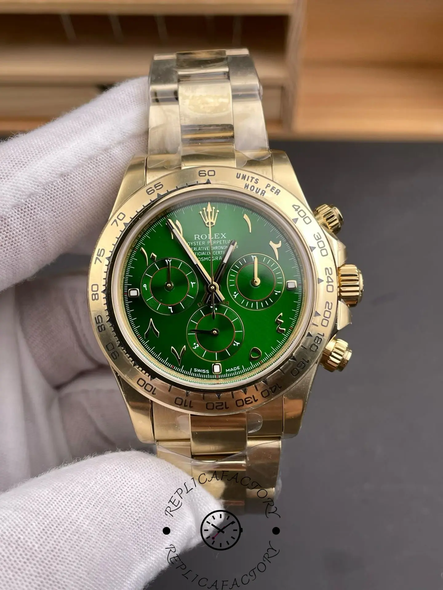 Front view of Rolex Daytona 116508 with green Arabic numeral dial, three chronograph subdials and yellow gold case.