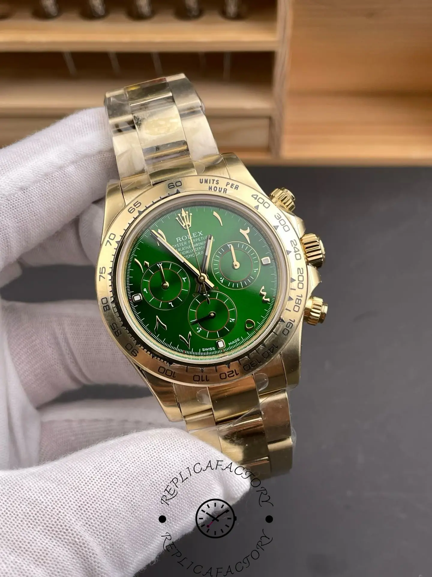 Angled view of Rolex Daytona 116508 highlighting green Arabic dial, gold pushers and polished Oyster bracelet.