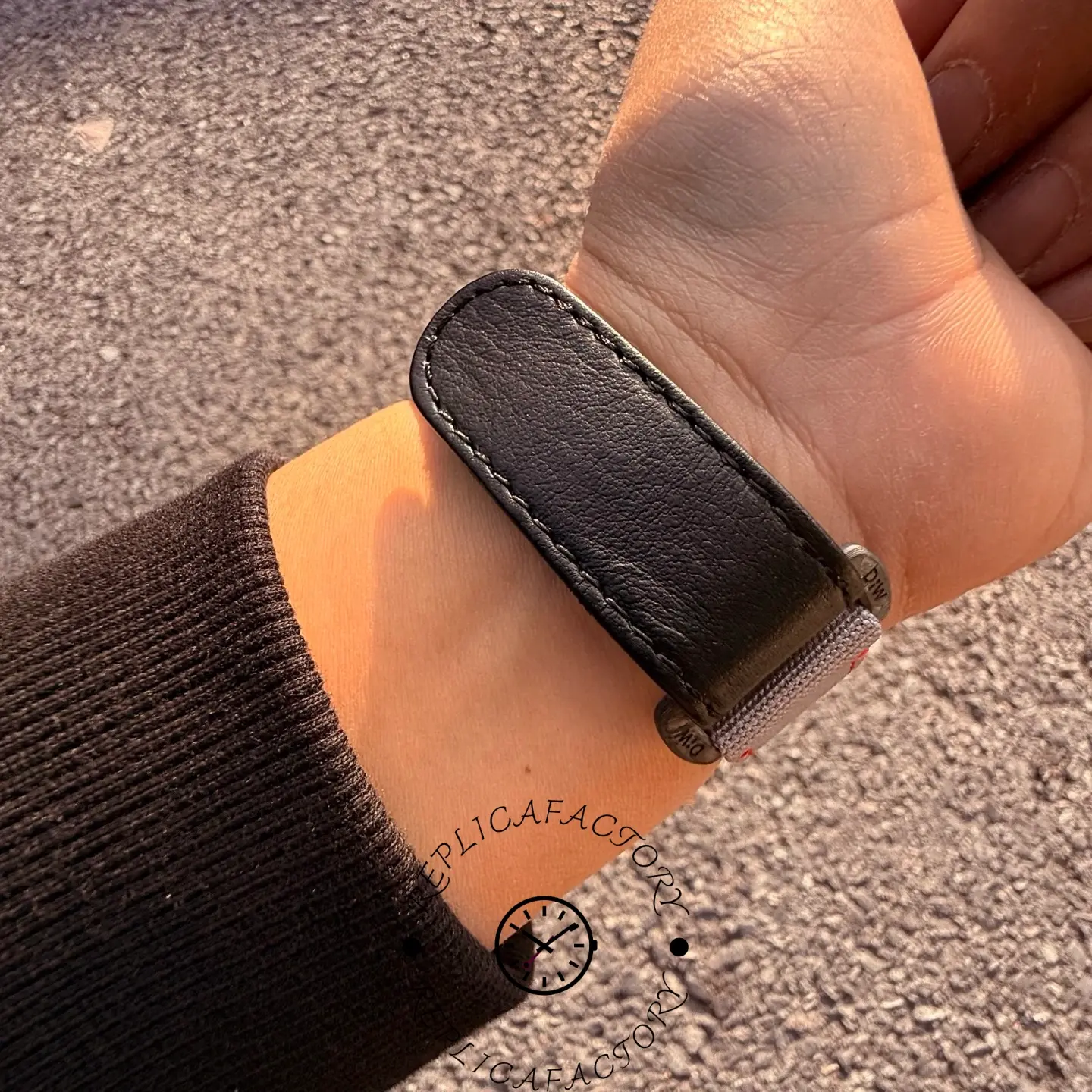 Close-up of the Rolex Daytona DiW strap clasp with black leather lining and grey fabric exterior.