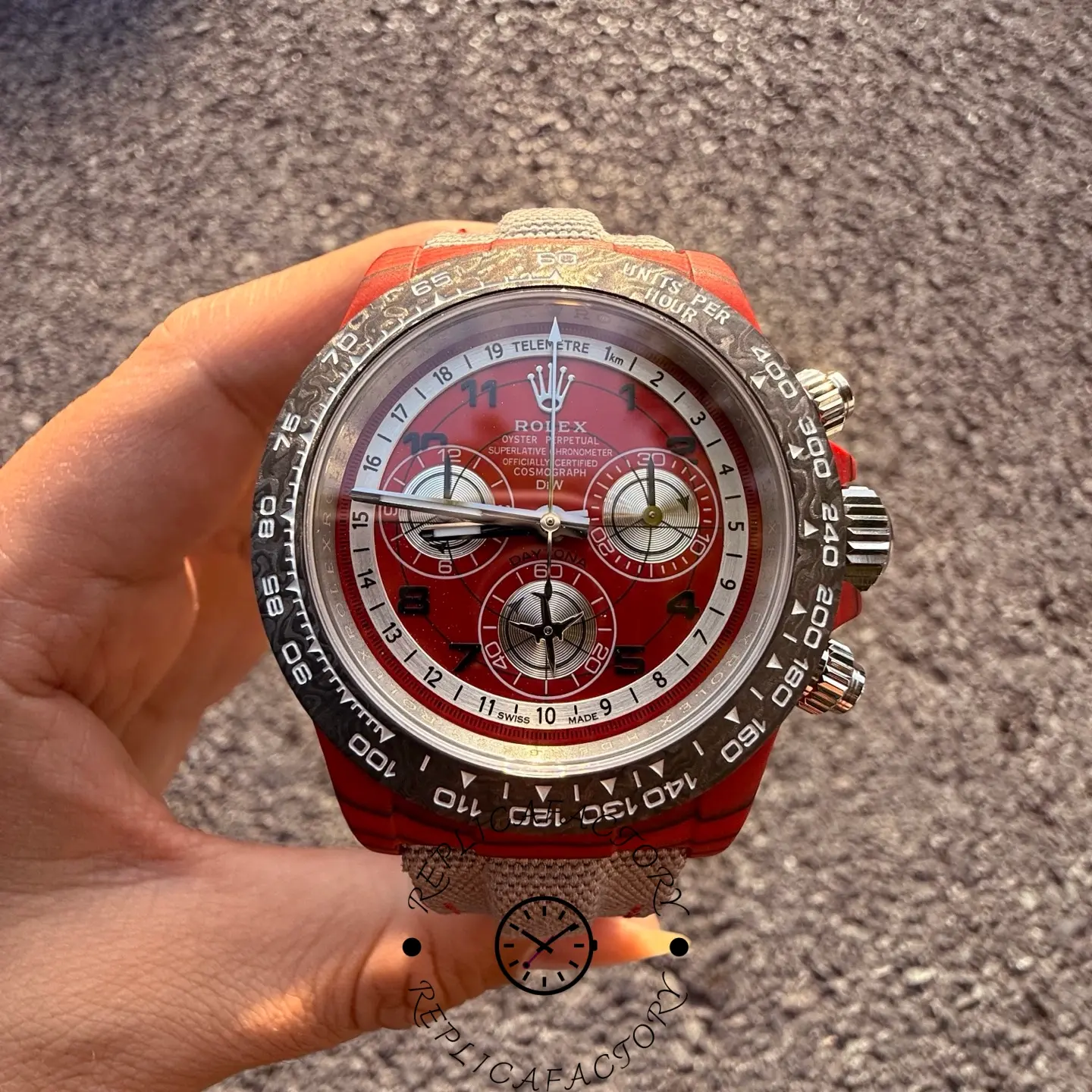 Straight-on close-up of the Rolex Daytona DiW red dial showing Arabic numerals and chronograph layout.