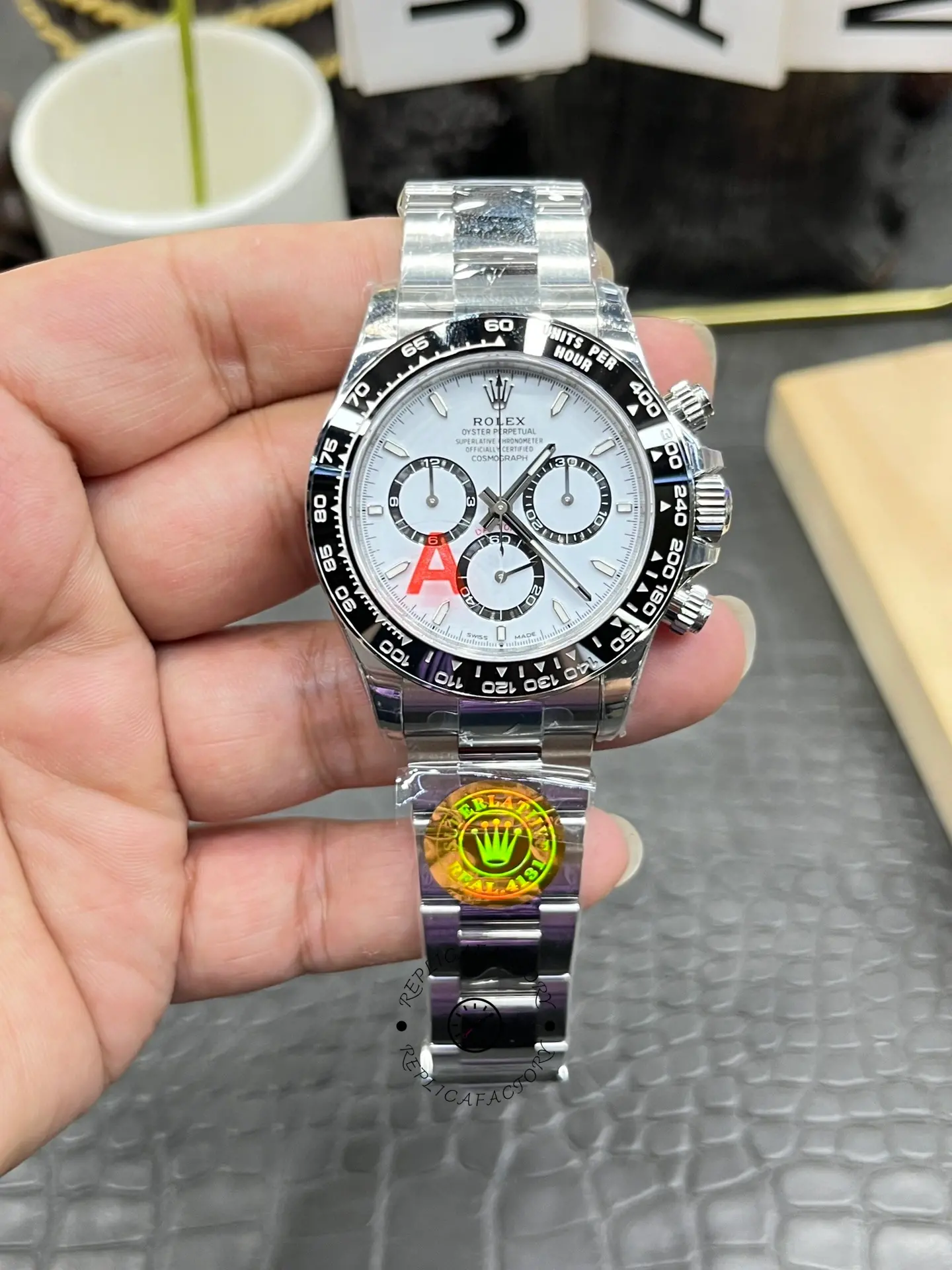 Rolex Daytona M126500LN-0001 handheld front view, white dial with black subdials, black bezel.